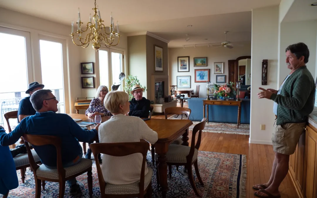 A family-owned and operated vineyard and winery with a group of people sitting around a dining room table.