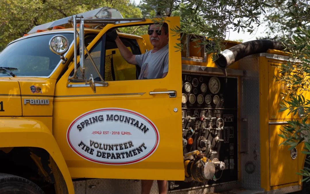 Sheldon on yellow fire truck that says spring mountain volunteer fire department